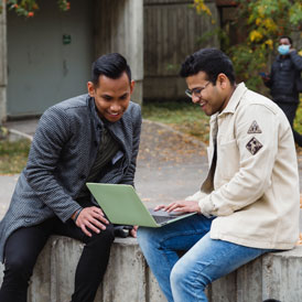 Students looking at laptop.